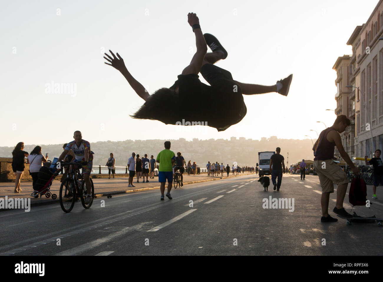 NAPLES - A young man jumps and makes a summersault on the Via Partenope. Stock Photo