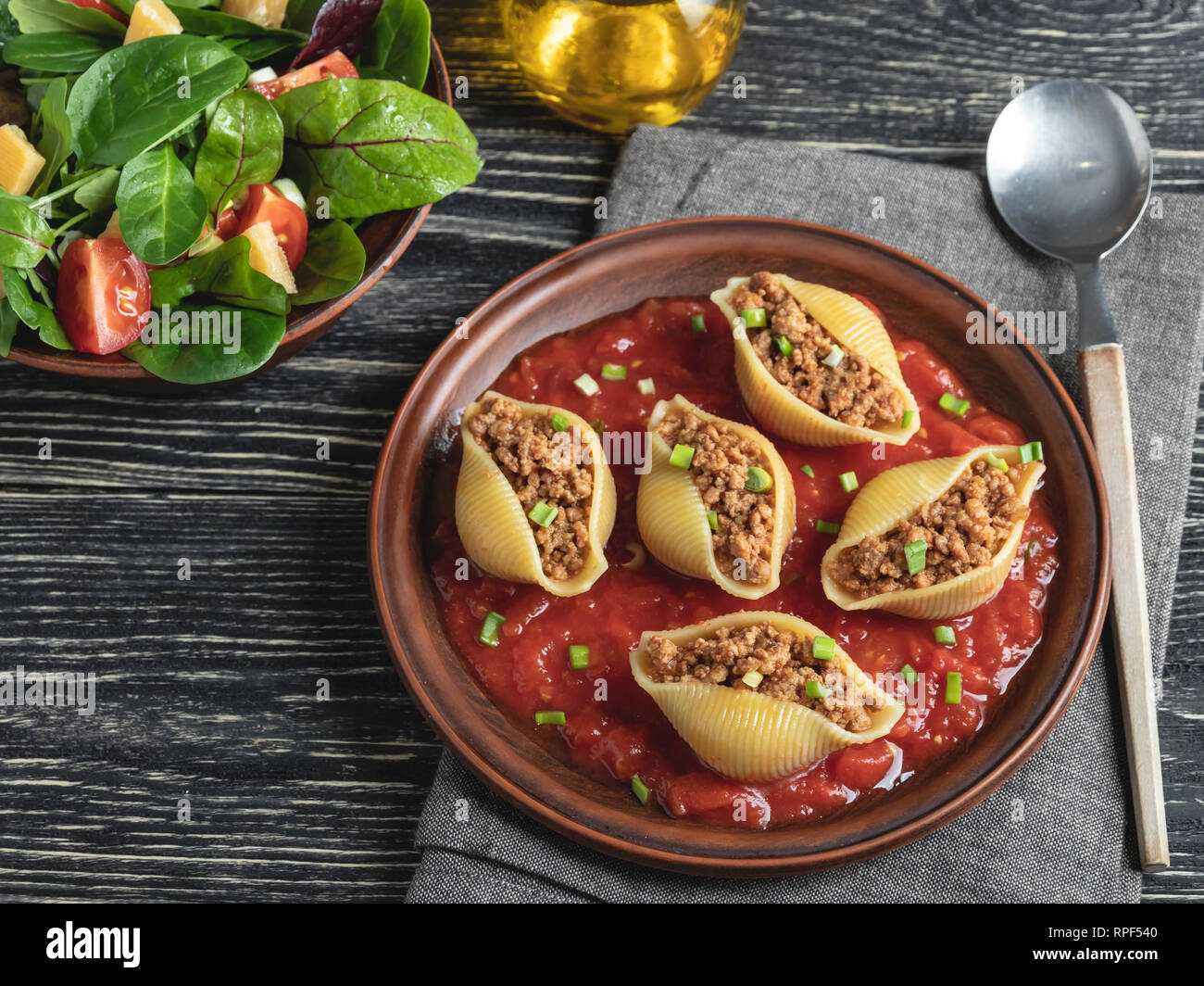cooked pasta conchiglioni stuffed minced meat, tomato sauce on plate Stock Photo