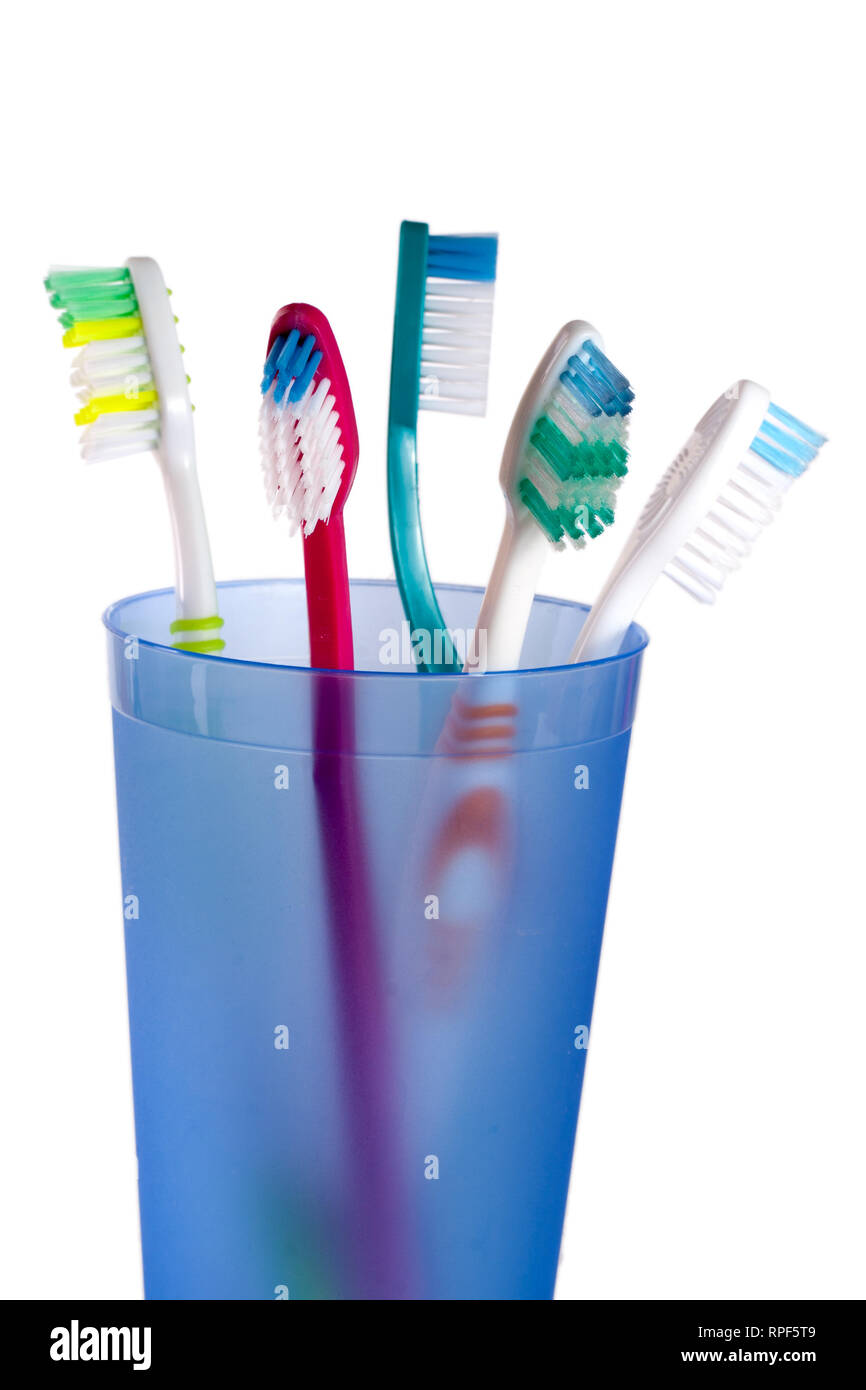 Toothbrushes in blue glass isolated on white background Stock Photo - Alamy