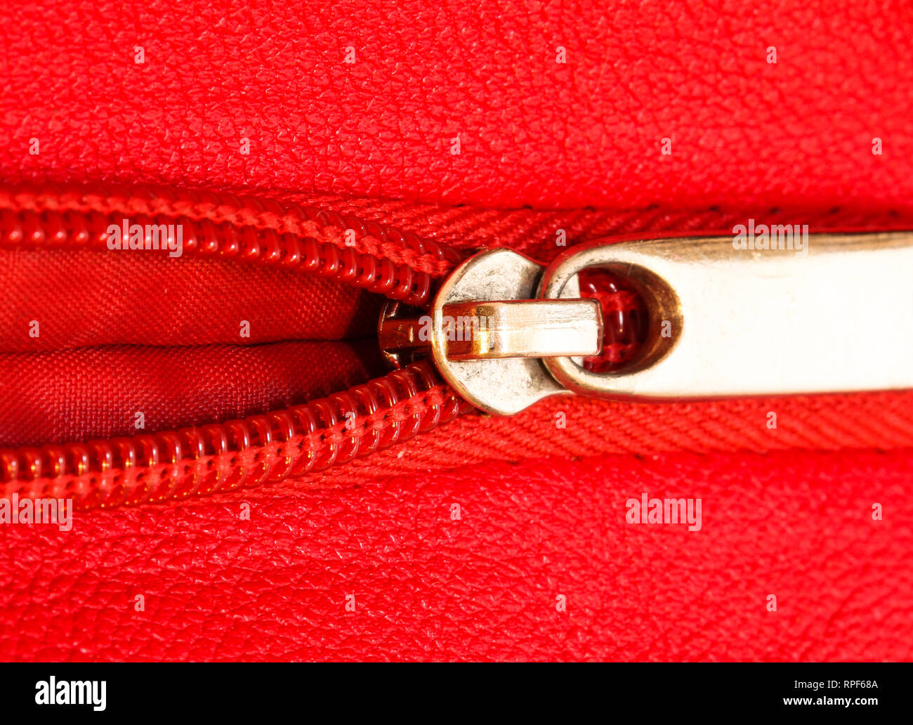 Metal zipper on intense red leather jacket or purse detail close up ...