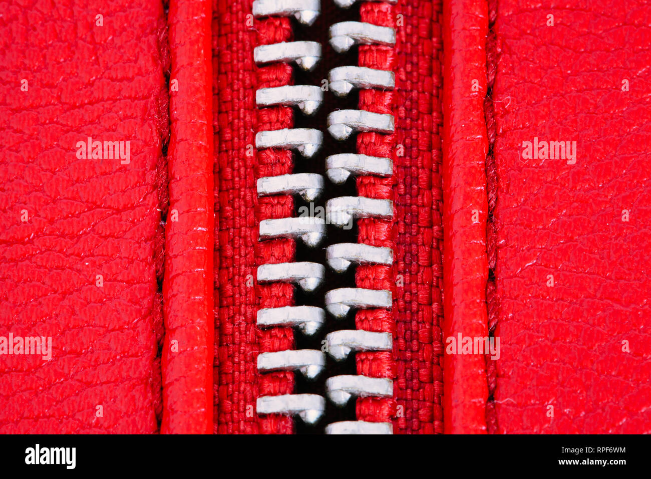 Metal zipper on intense red leather jacket or purse detail close up