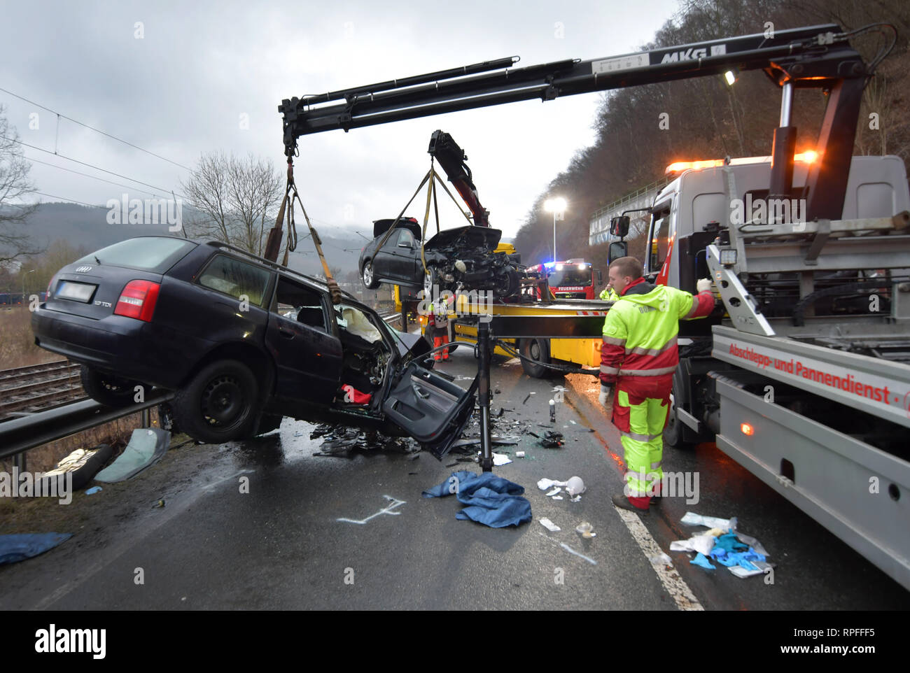 Olpe, Germany. 22nd Feb, 2019. Destroyed cars are transported after a serious accident. Three people died in a frontal collision between two cars in the Sauerland region on Friday morning. A fourth person was seriously injured and taken to hospital, said a police spokeswoman. The cars had collided on the federal road between Finnentrop and Lenhausen (Olpe district). At first, the speaker was unable to say anything about the identity of the victims. Credit: Markus Klümper/dpa - ATTENTION: Indicator was pixelated for legal reasons/dpa/Alamy Live News Stock Photo