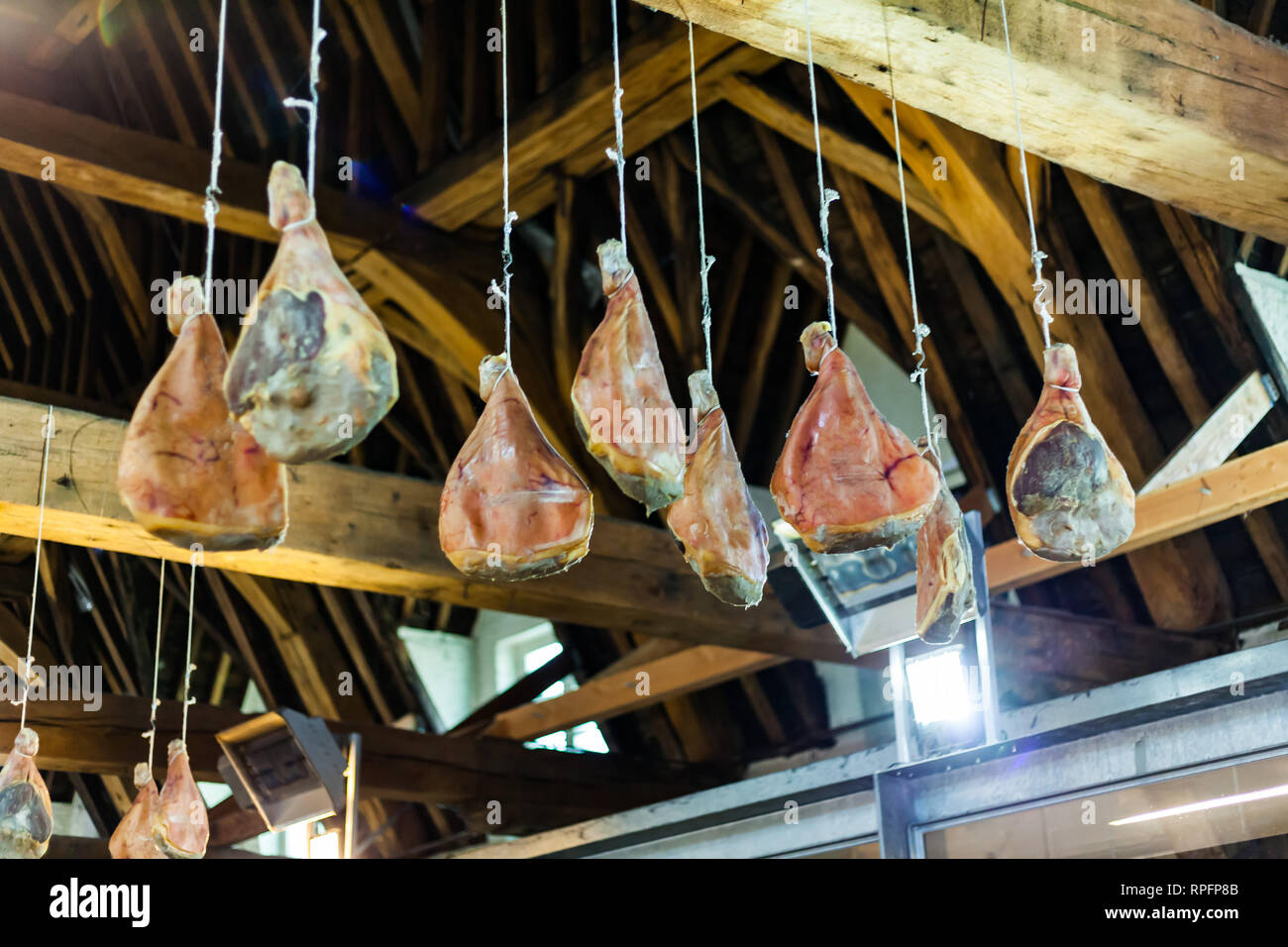 Hooked Ham On Wooden Beams That Hang From The Ceiling