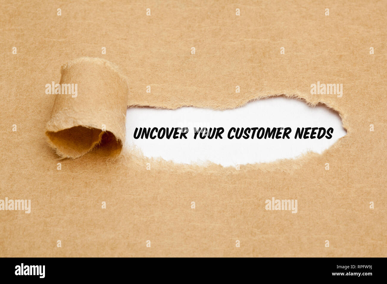 Text Uncover Your Customer Needs appearing behind torn paper. Concept about the importance to understand the demands, requirements and expectations of Stock Photo