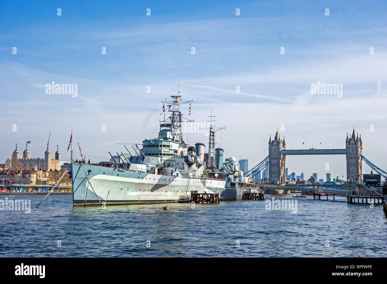 HMS Belfast moored on the River Thames in front of Tower Bridge and the Tower of London Stock Photo