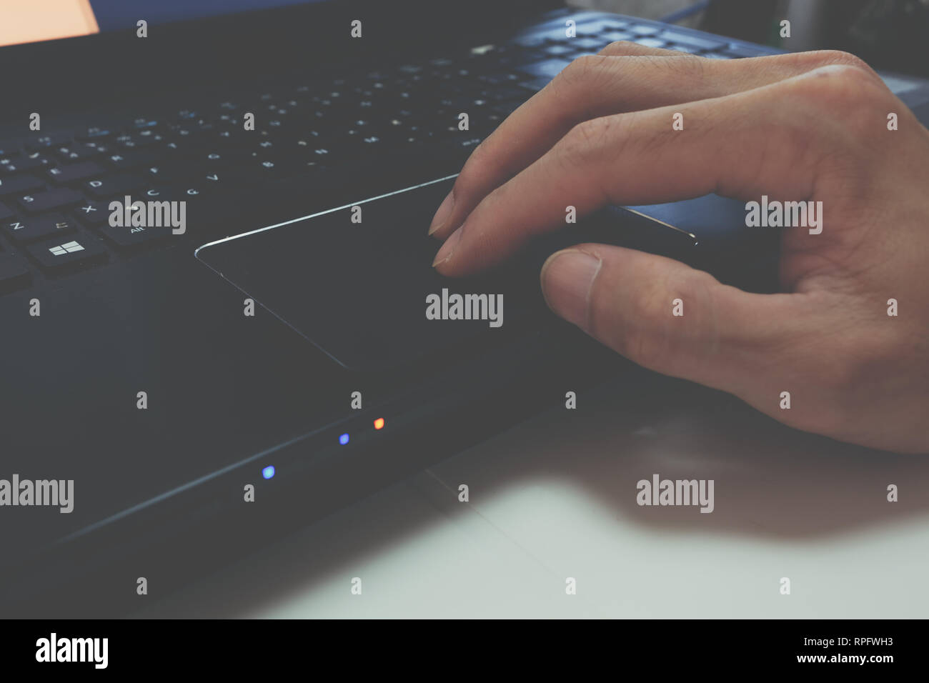Man's hand using black laptop touchpad, trackpad use, drag and drop, gestures, keypad Stock Photo