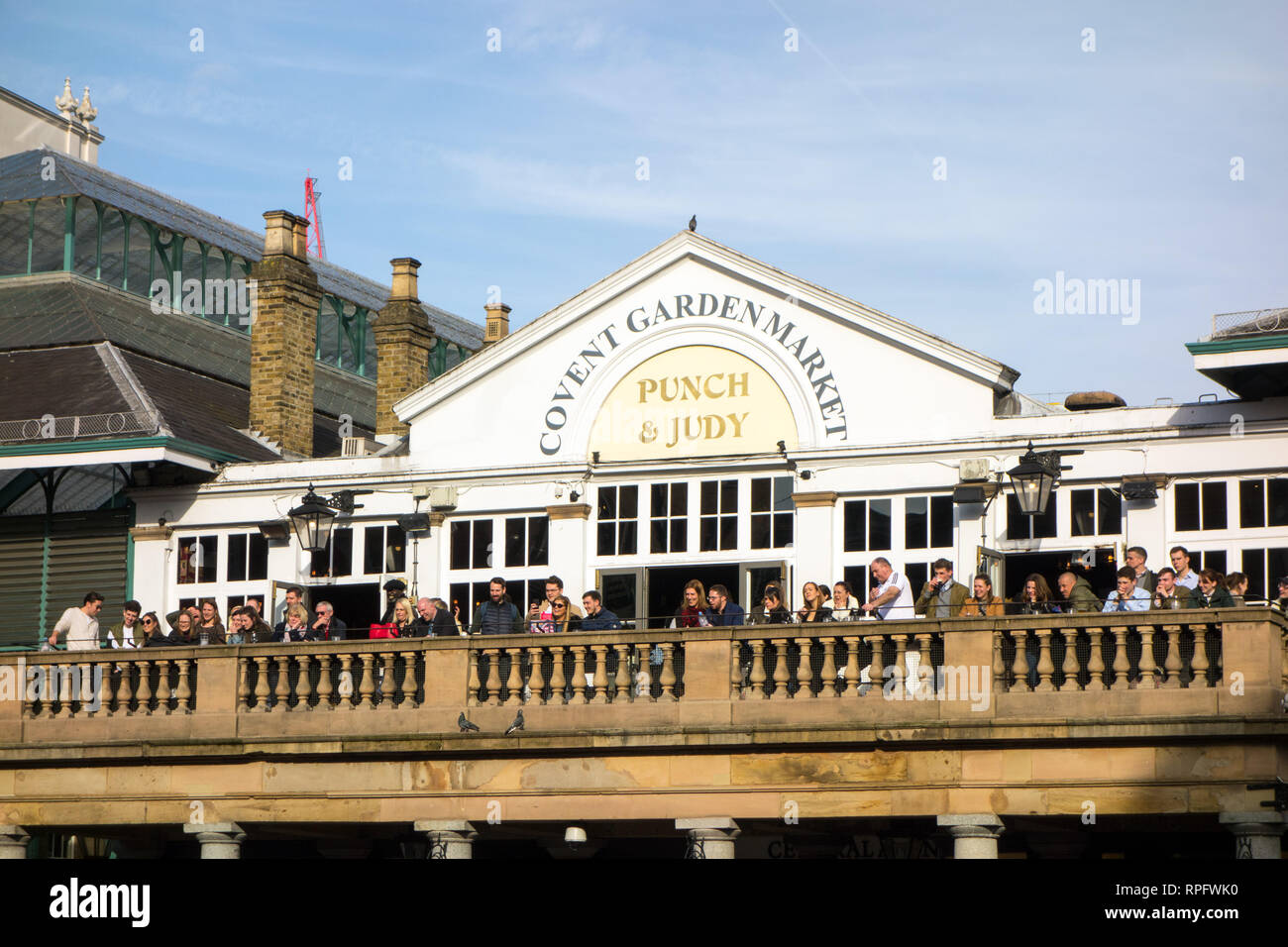 People men and women watching a street performer from the balcony of the Punch and Judy tavern inn pub in London's Covent  Garden London Stock Photo