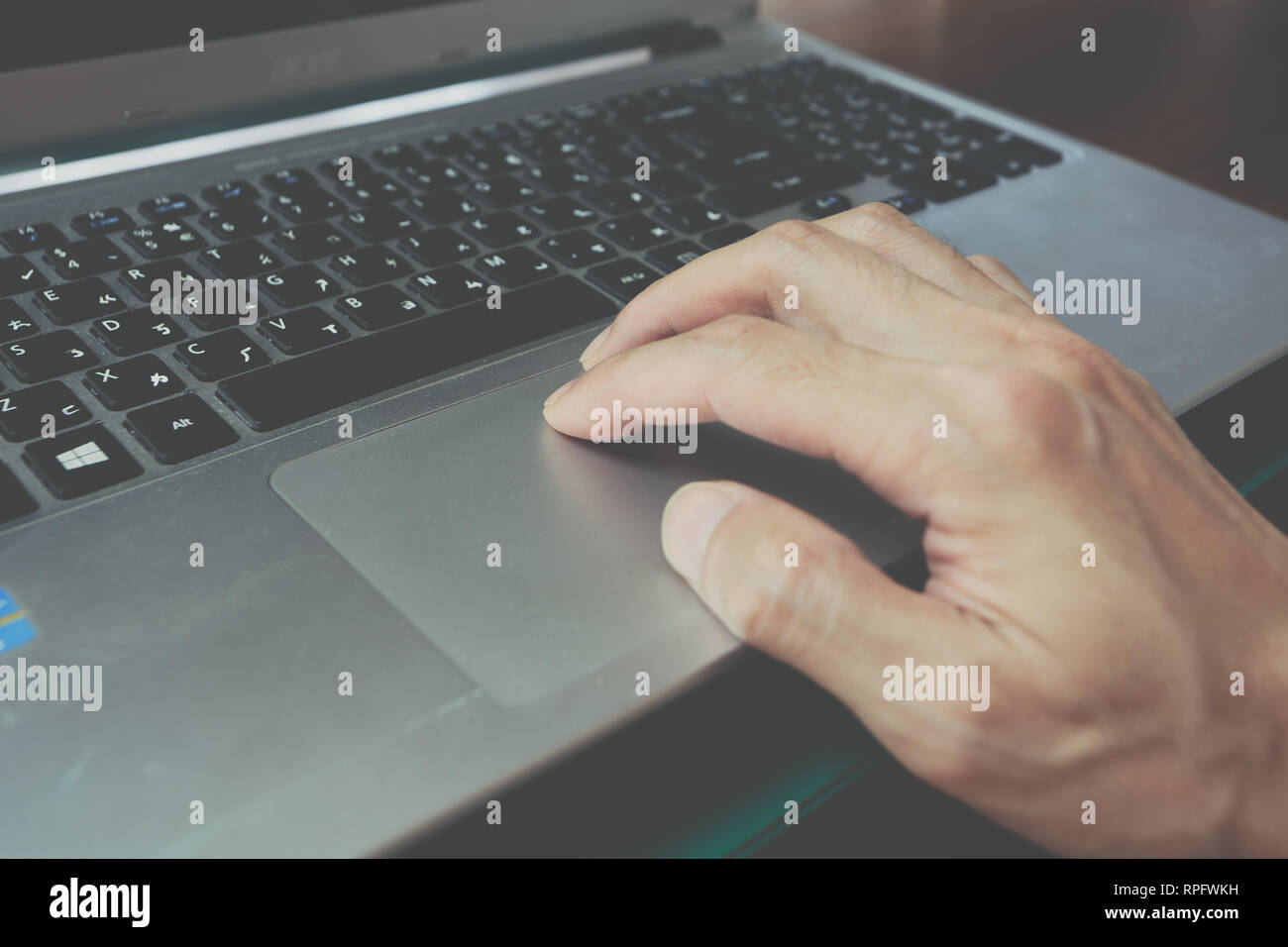 Man's hand using silver laptop touchpad, trackpad use, drag and drop, gestures, keypad Stock Photo