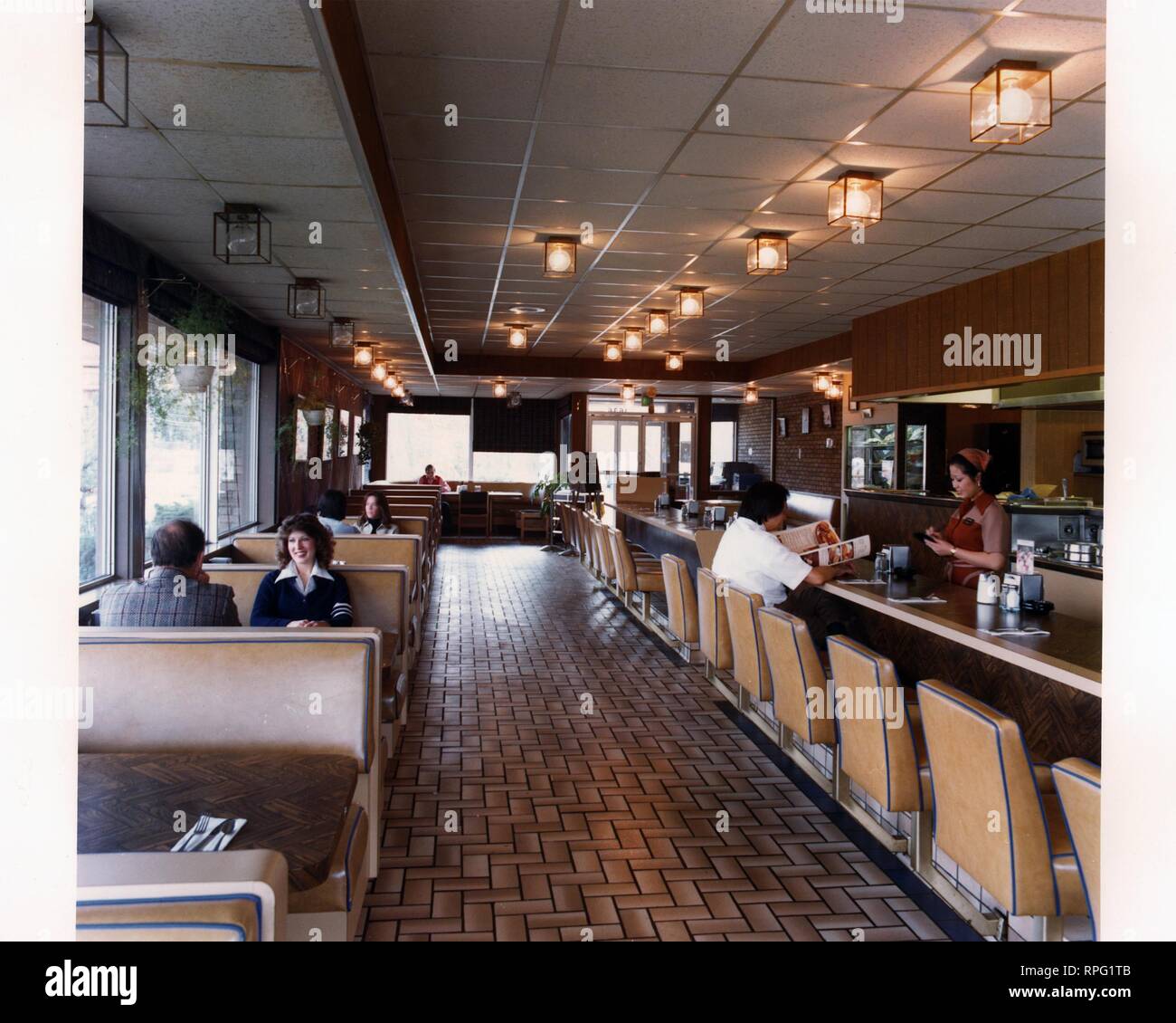 Interior view of customers and staff inside a Jolly Tiger Restaurant equipped with energy efficient lighting, 1980. Image courtesy US Department of Energy. () Stock Photo