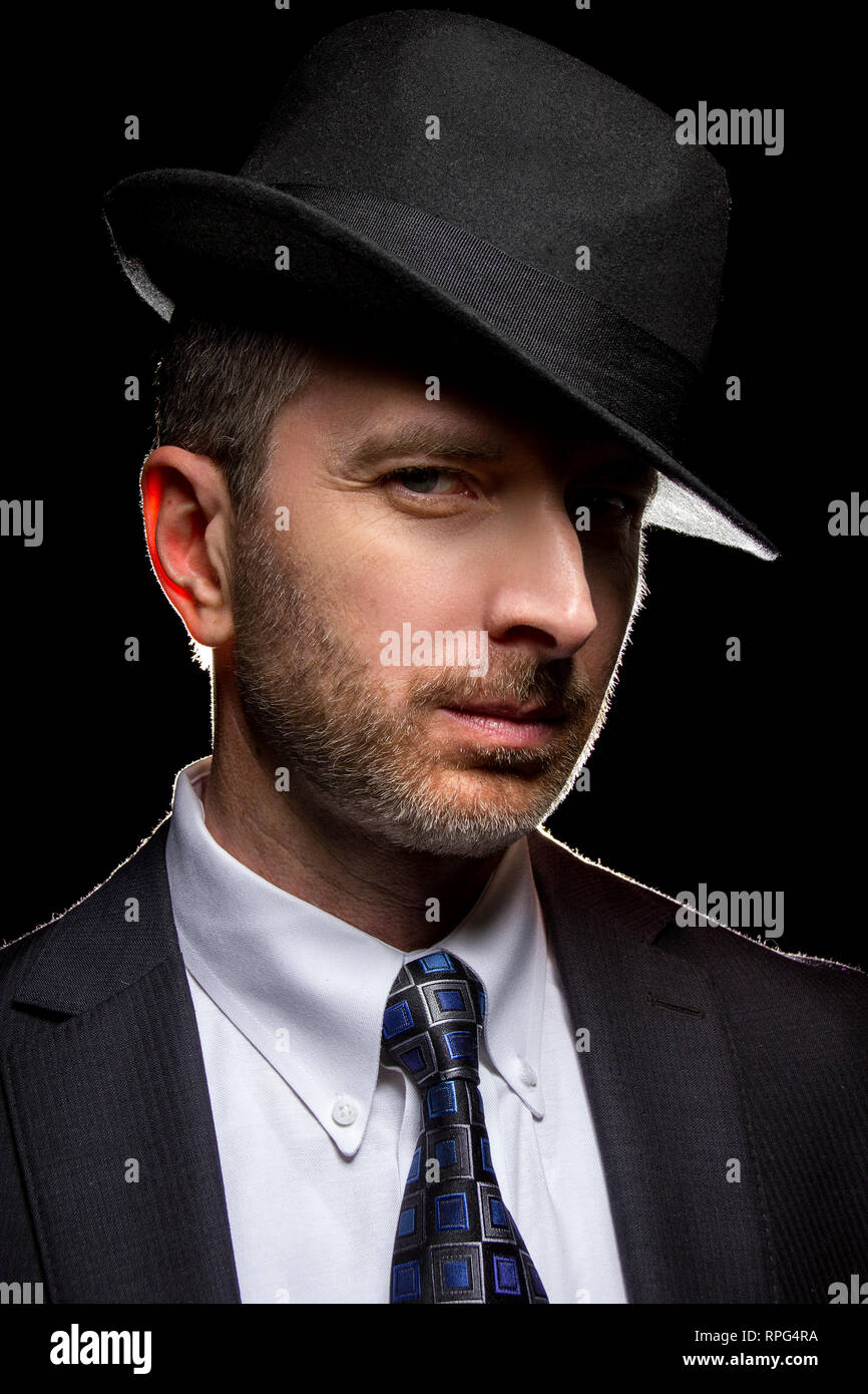 Man wearing a fedora hat as a film noir detective or gangster Stock Photo -  Alamy