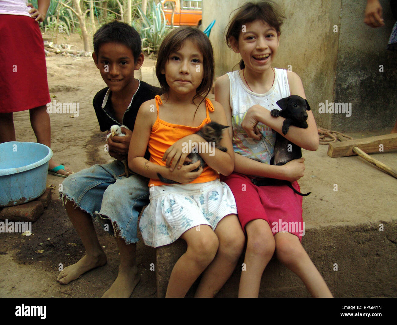 EL SALVADOR Children on a farm holding chicks, puppies and kittens, San Francsisco Javier Stock Photo