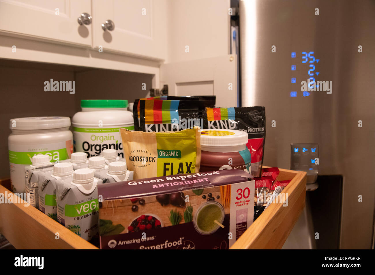 Vegan products / vegetarian superfood products on a shelf / plant-based protein - flax - meal-replacement shakes - Kind grain granola  and nut bars Stock Photo