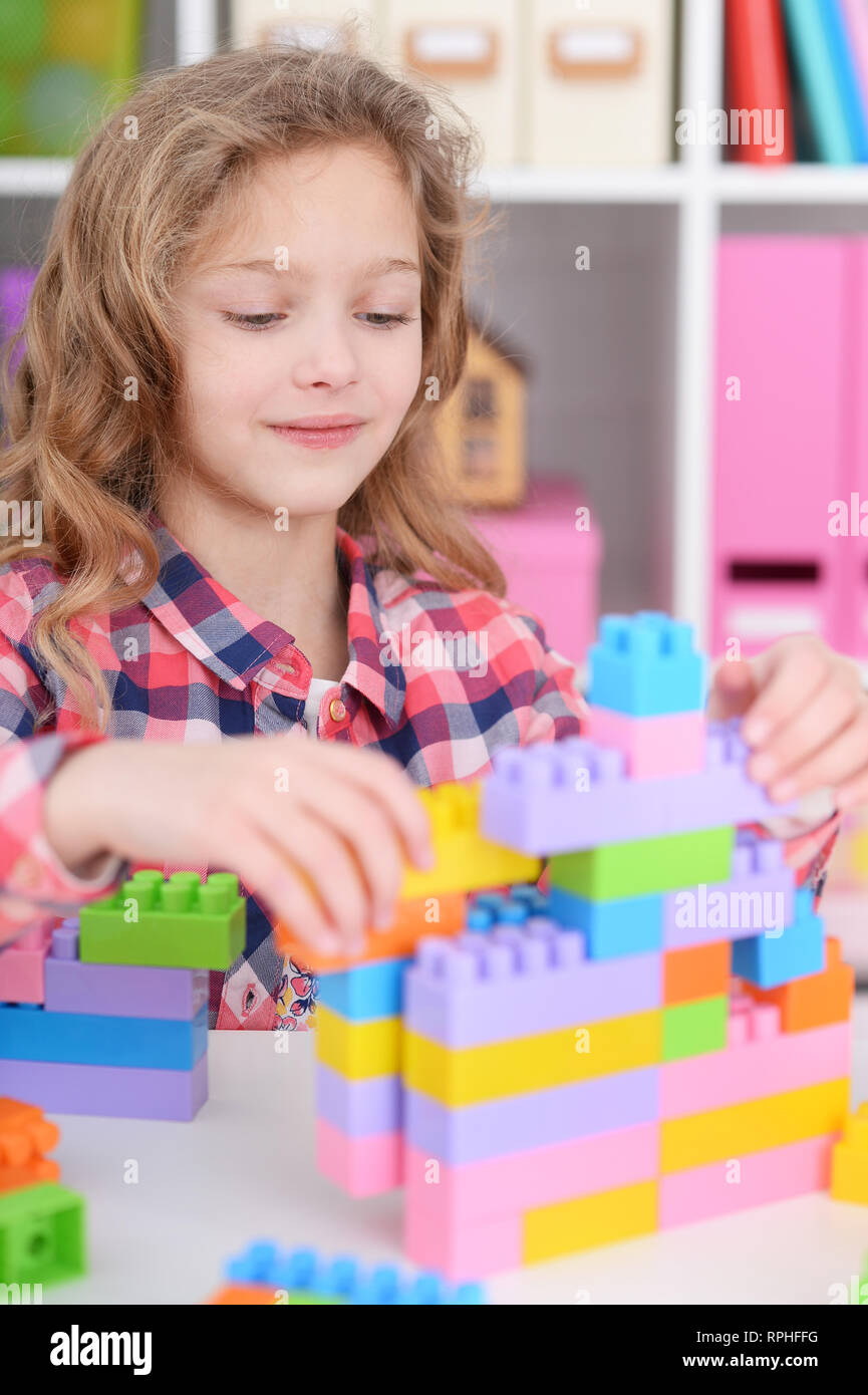 Cute little girl playing with colorful plastic blocks in her room Stock ...