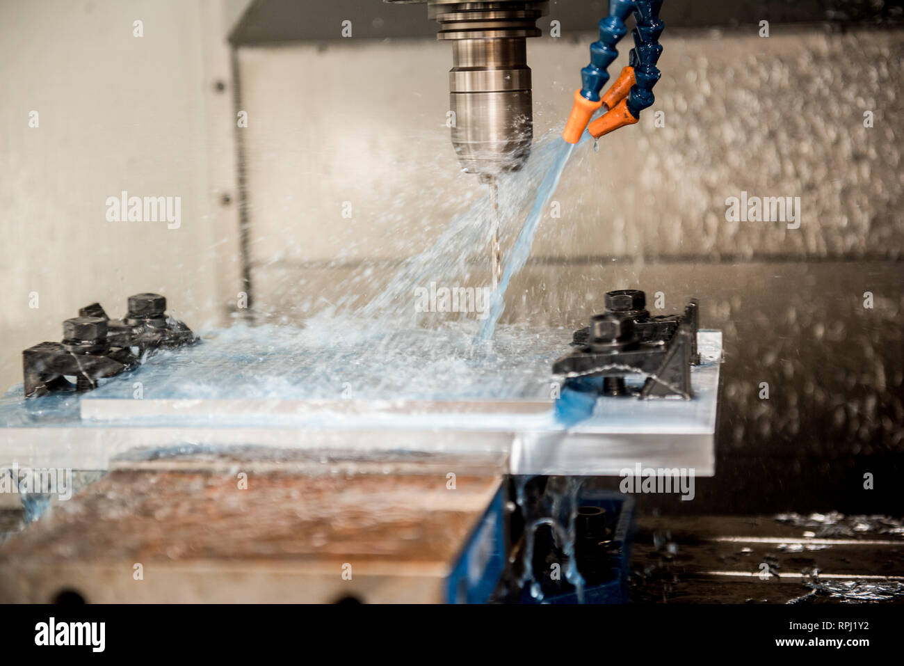 A vertical mill computer numeric control system sprays water and coolant on an aluminum plate at Dover Air Force Base, Delaware, Jan. 6, 2019. The 512th Airlift Wing, Dover AFB, assisted the 920th Rescue Wing at Patrick AFB, Florida, in manufacturing parts for an HH-60G Pave Hawk helicopter. (U.S. Air Force photo by Staff Sgt. Damien Taylor) Stock Photo