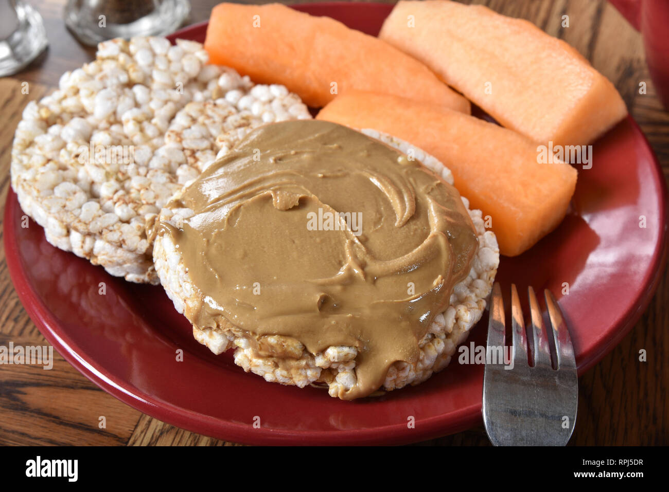 Rice cake with organic peanut butter and cantaloupe wedges Stock Photo Alamy