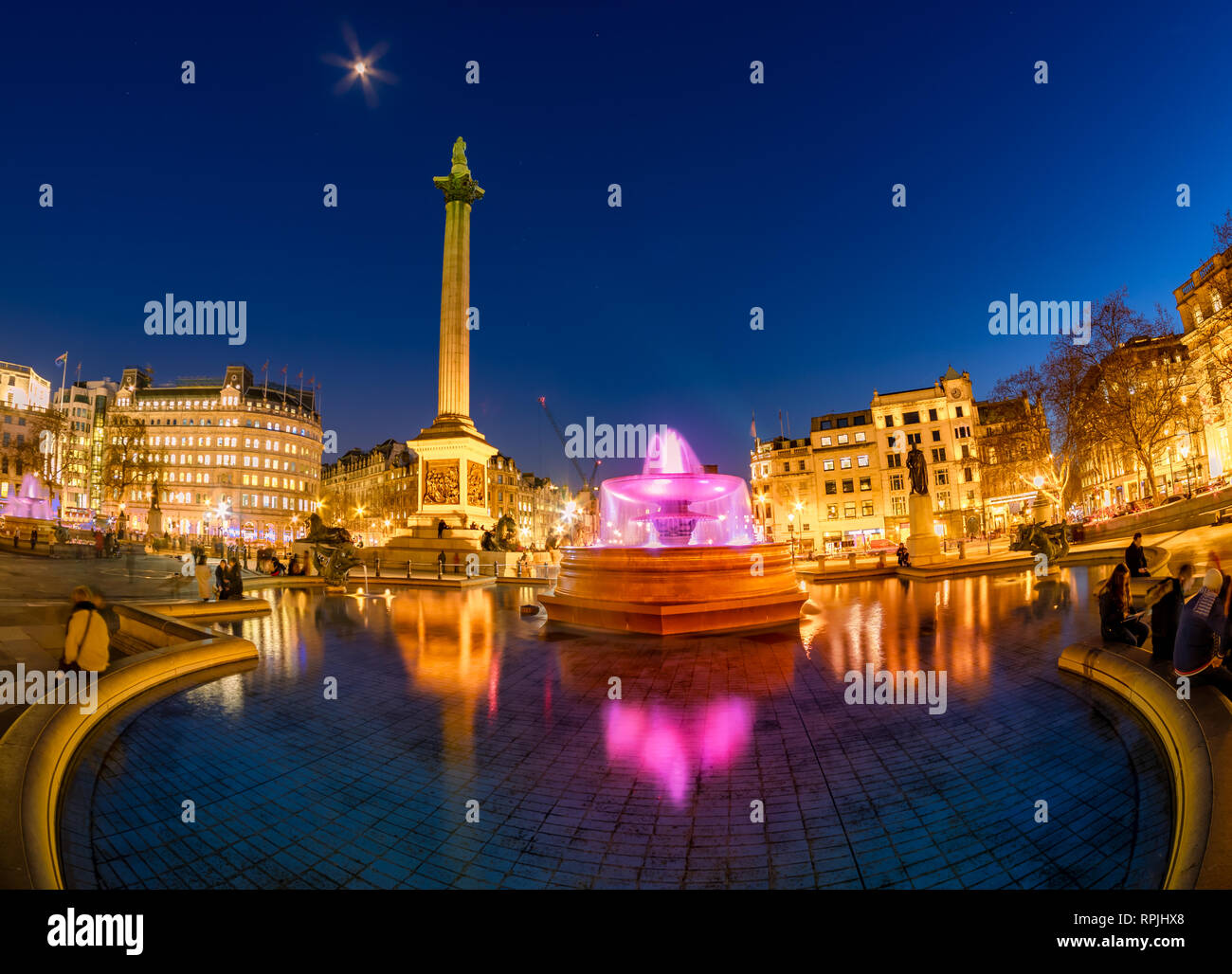 Beautiful cityscape view of Trafalgar square in evening lights with the famous Nelson's Column and fountain in Central London, UK Stock Photo