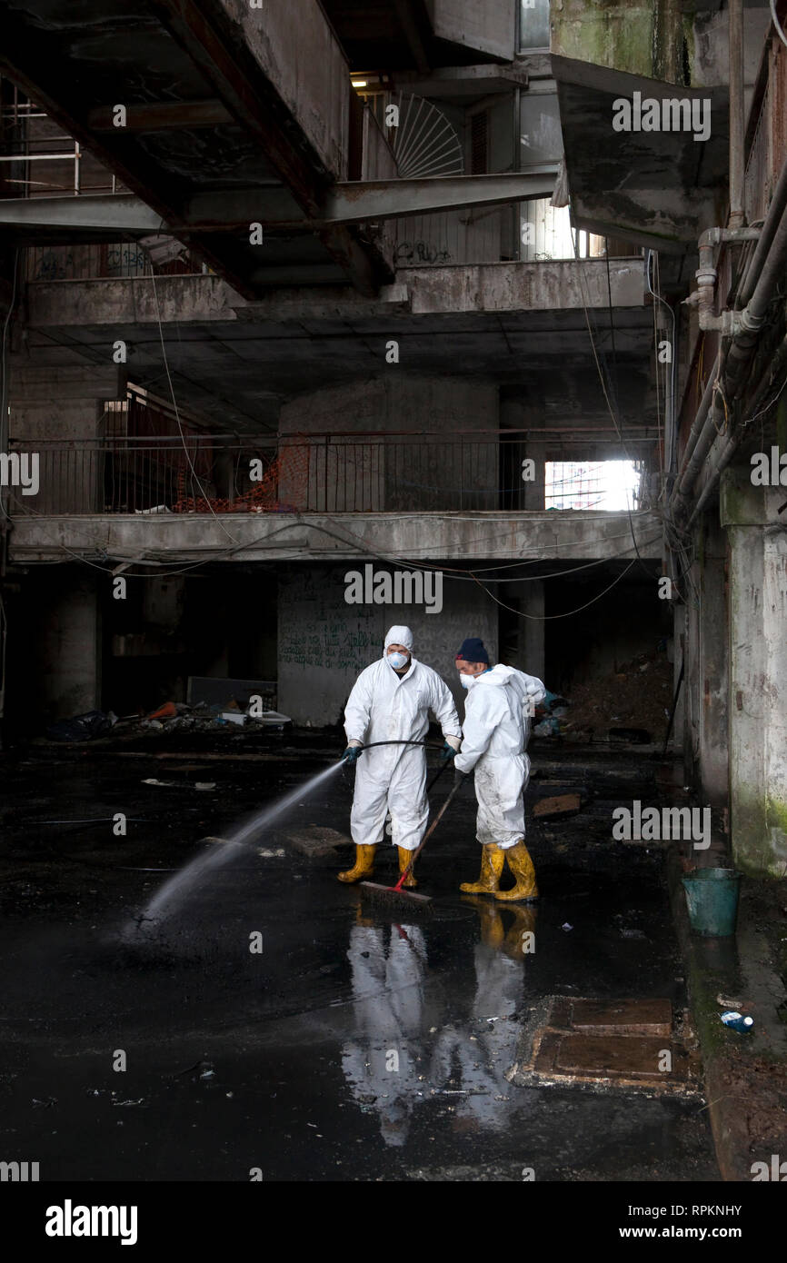 A cleaning team working inside one of the buildings known as the vele di Scampia in the north of Naples in Camorra territory. Stock Photo