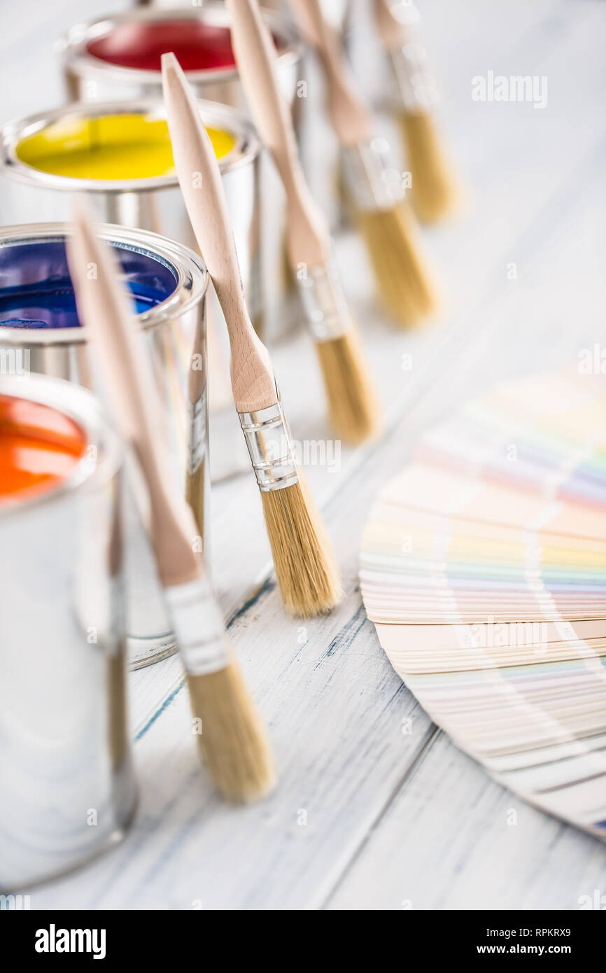 Paint cans brushes and color palette on table. Stock Photo