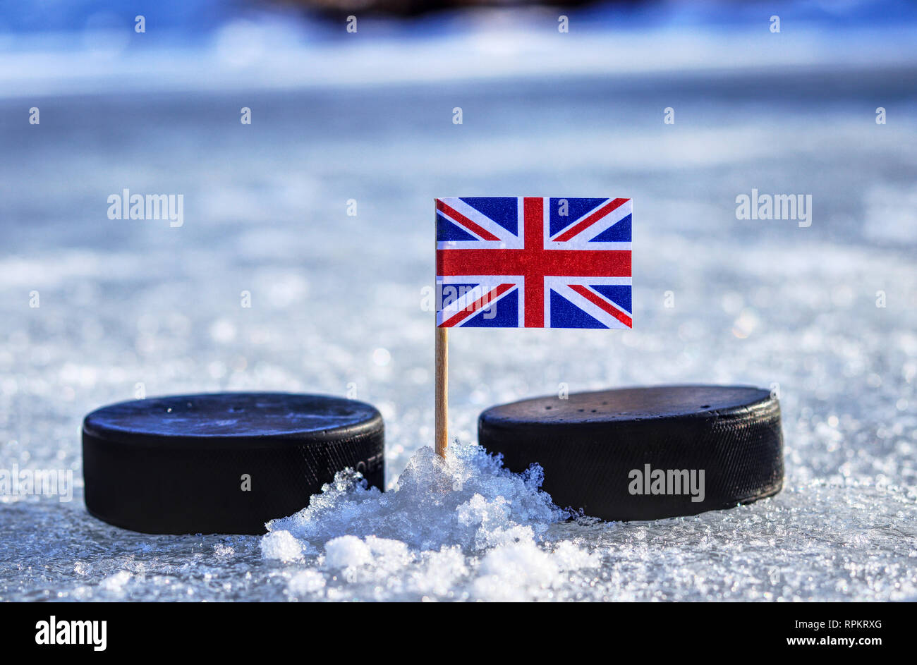 A British Flag On Toothpick Between Two Hockey Pucks On Ice In Winter Classic A Great Britain A British Flag On Toothpick Between Two Hockey Pucks On Ice In Winter Classic A Great Britain