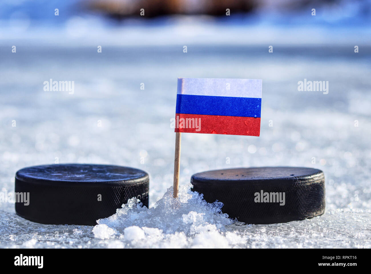 A russian flag on toothpick between two hockey pucks on outdoor ice. A russia playing in group B. 2019 Ice Hockey World Championship in Bratislava. Stock Photo