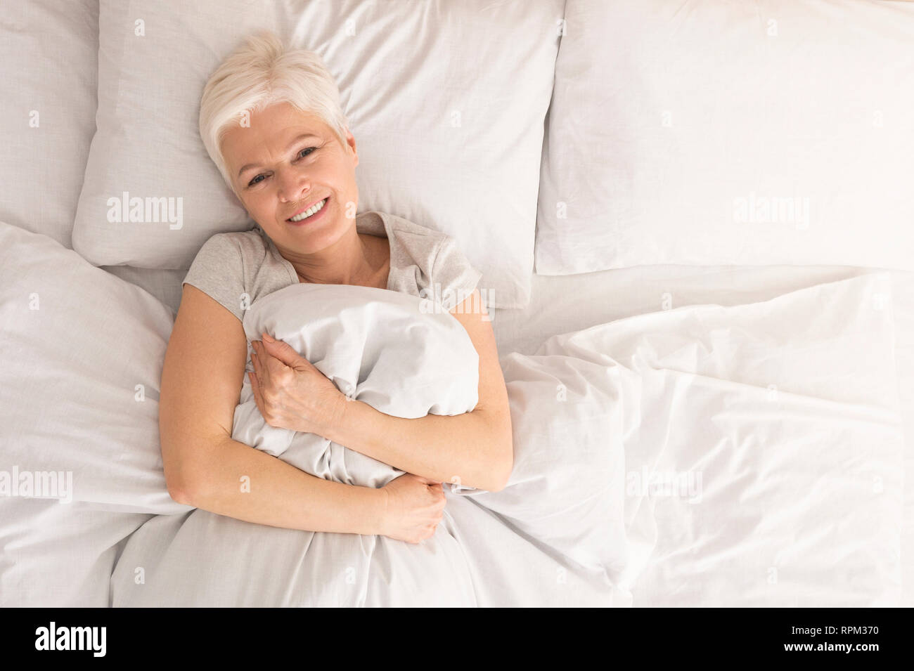 Attractive woman relaxing in bed, morning awakening, health and beauty, leisure Stock Photo