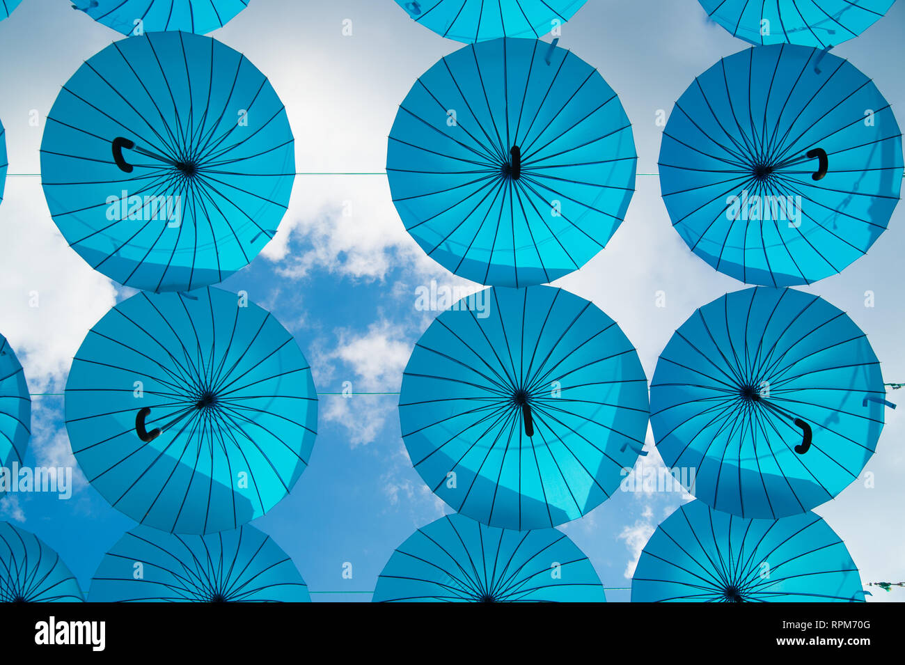 Blue umbrellas float in sky on sunny day. Umbrella sky project