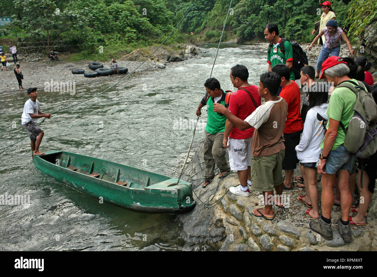 Visitors to Gunung Leuser National Park waiting for boat to cross the Bahorok River at Bukit Lawang, North Sumatra, Indonesia Stock Photo