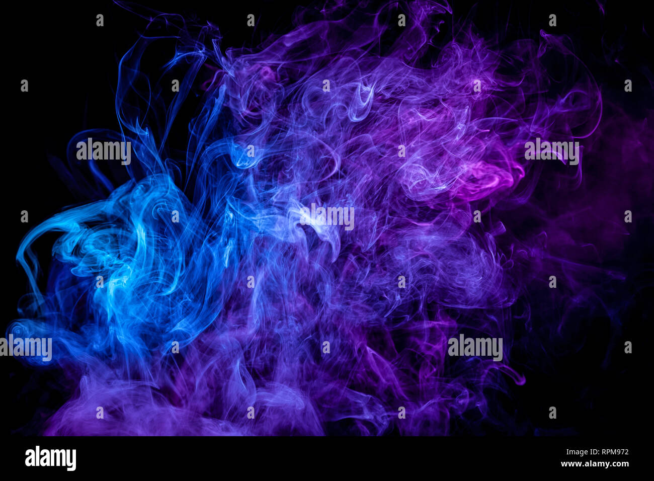 Thick colorful blue and purple smoke on a black isolated background ...