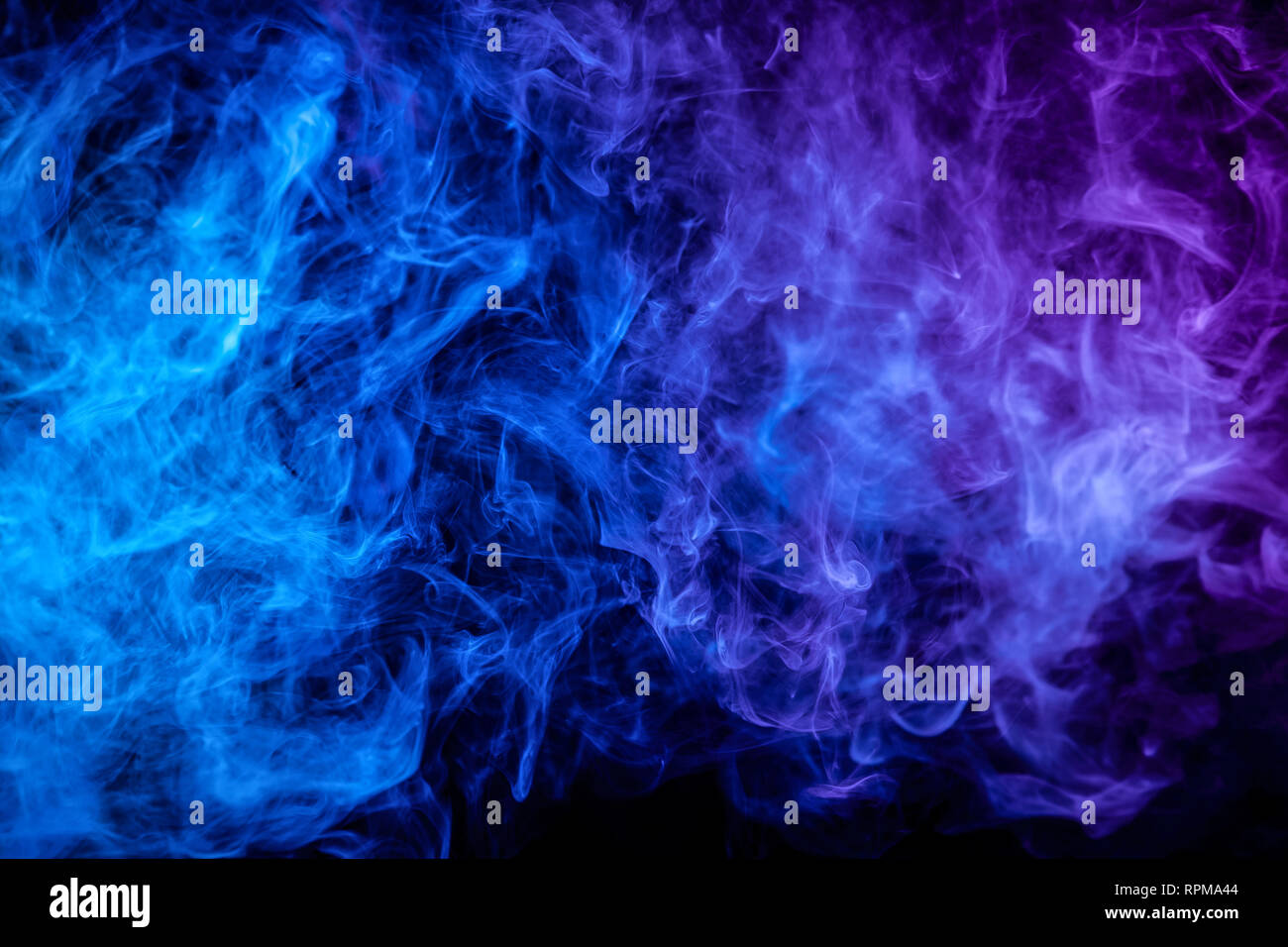 Blue and purple bomb smoke on black isolated background Stock Photo - Alamy