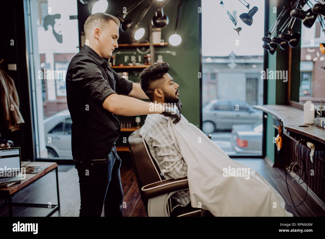 Handsome Bearded Man Is Smiling While Having His Hair Cut By