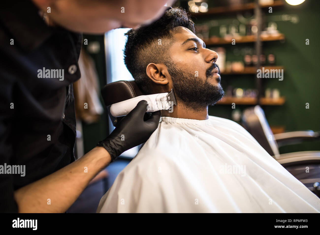 Young Bearded Man Getting Haircut By Hairdresser With Electric