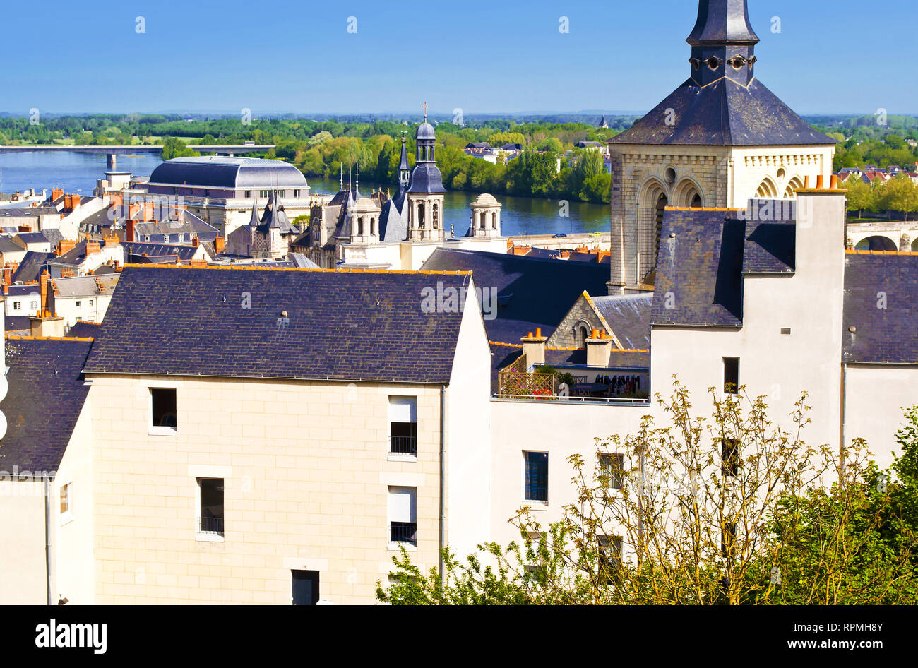 Breathtaking view on amazing small town Saumur, France. Many white and gray houses near a Loire river. Closeup of garden on the open roof. Warm spring Stock Photo
