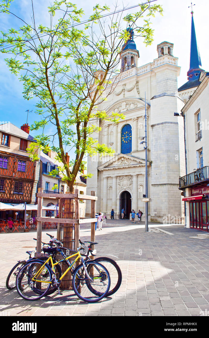 Saumur, France - April 22, 2018: Eglise St Pierre church in solitary city center of a small town Saumur, orange beam houses, parked bicycles, warm spr Stock Photo