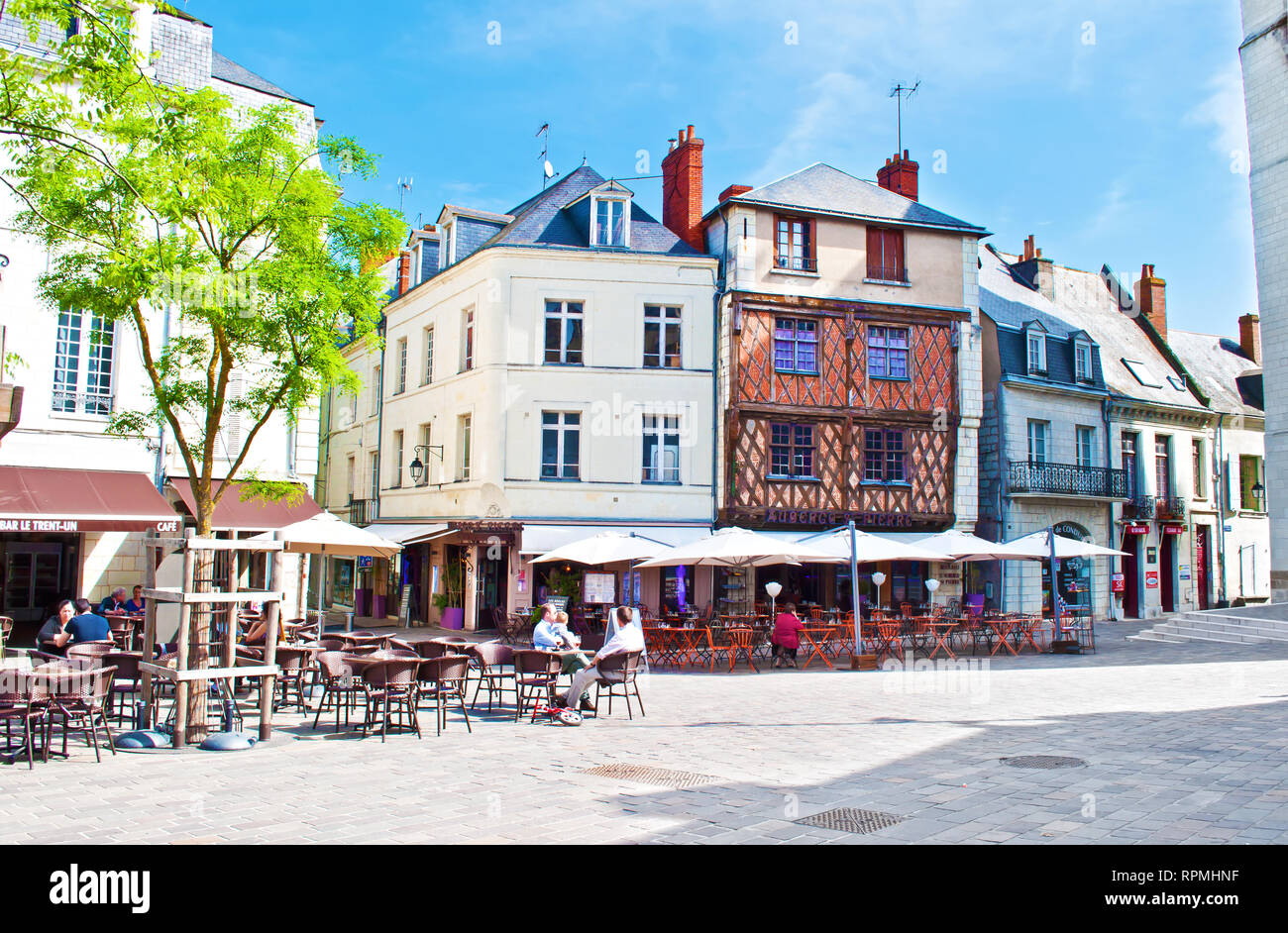 Saumur, France - April 22, 2018: Eglise St Pierre square in solitary city center of a small town Saumur, orange beam houses, cafes with many chairs on Stock Photo