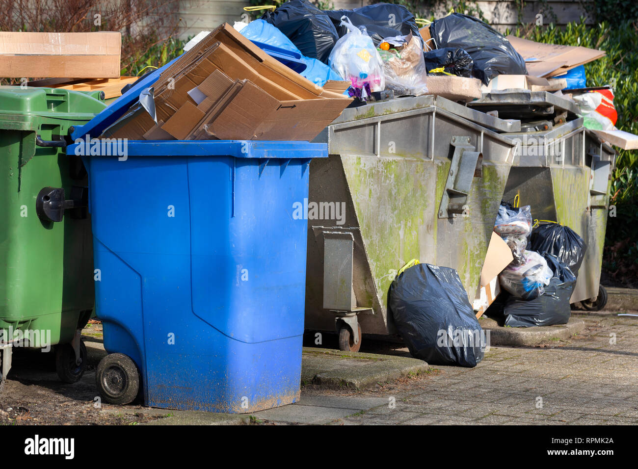 Overloaded garbage containers in a street in Capelle aan den IJssel in