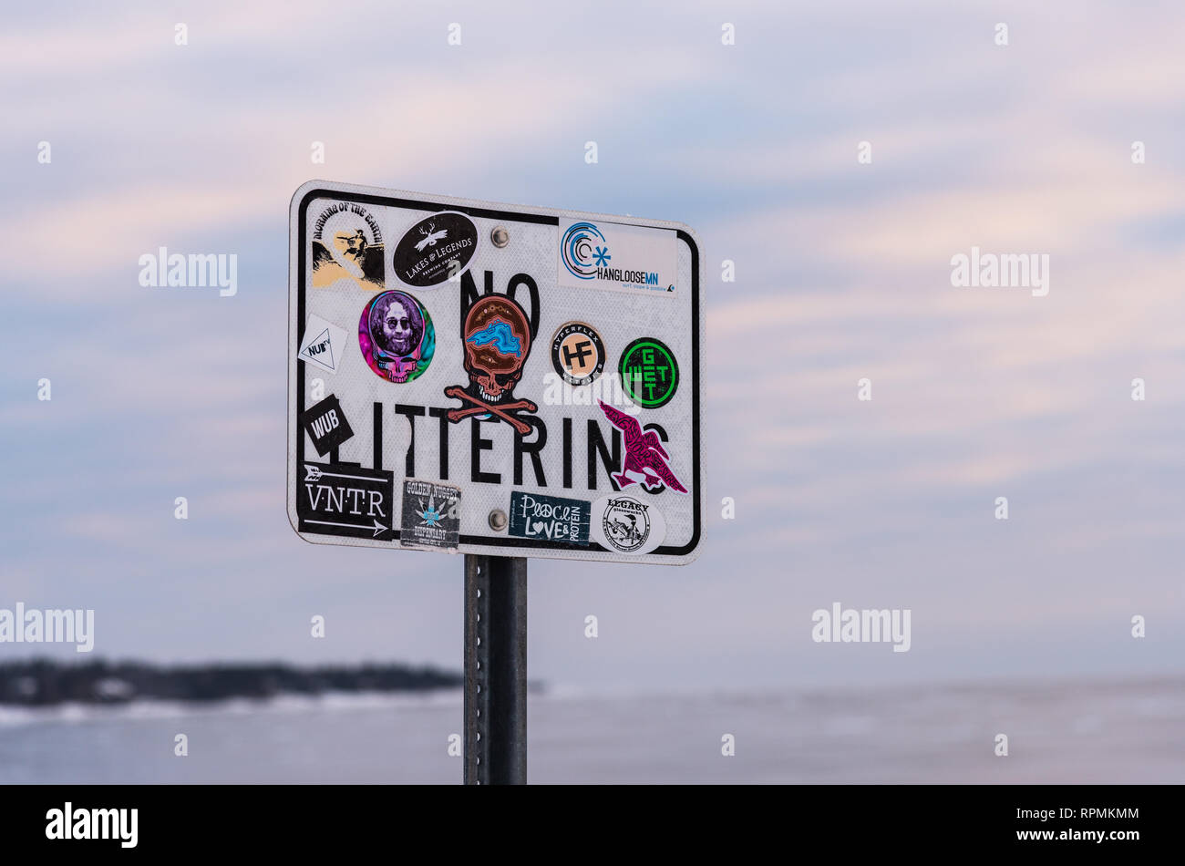 A 'No Littering' sign covered by colorful stickers. Duluth, Minnesota, USA. Stock Photo
