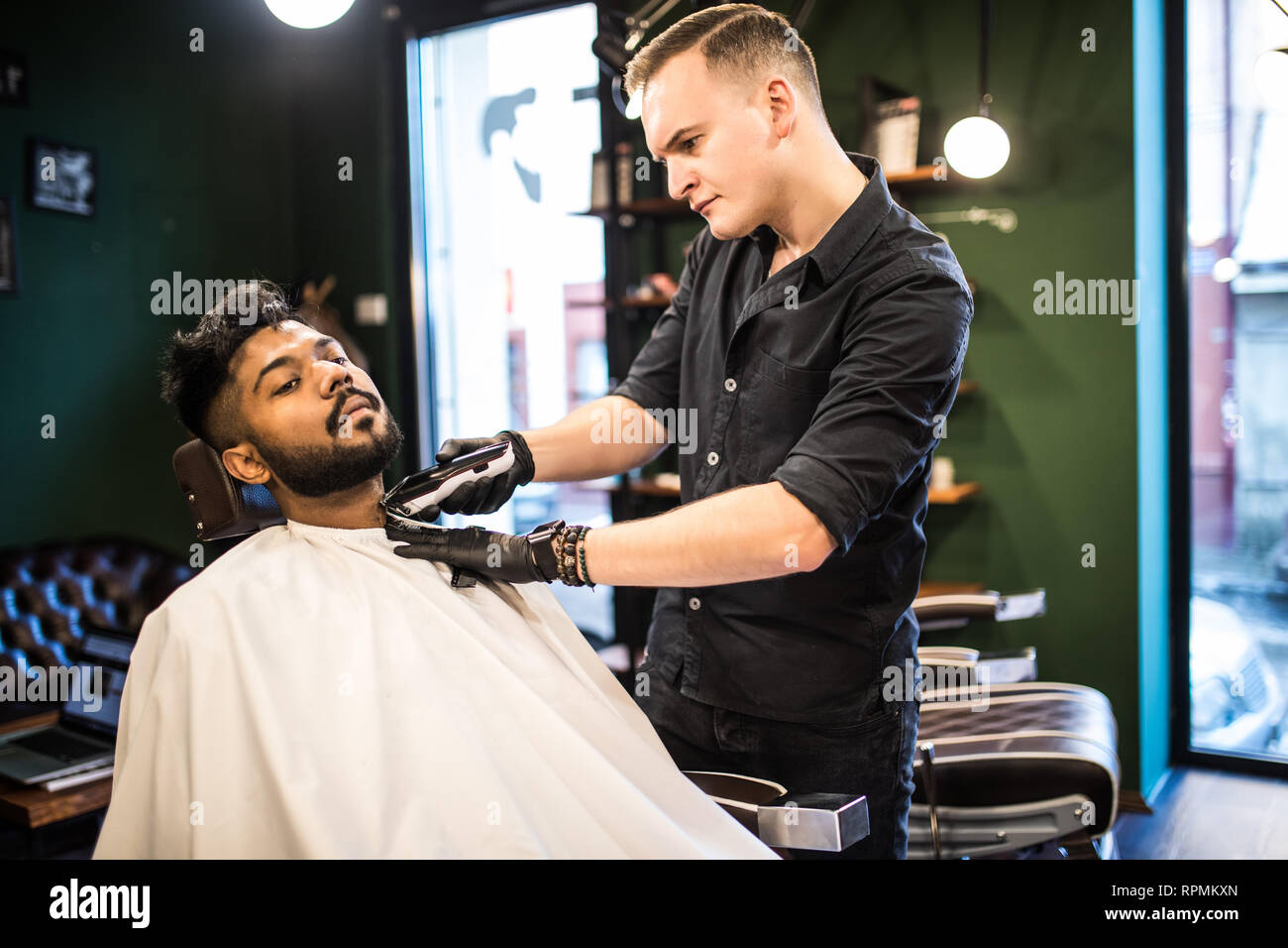 Client during beard and moustache grooming in barber shop Stock Photo