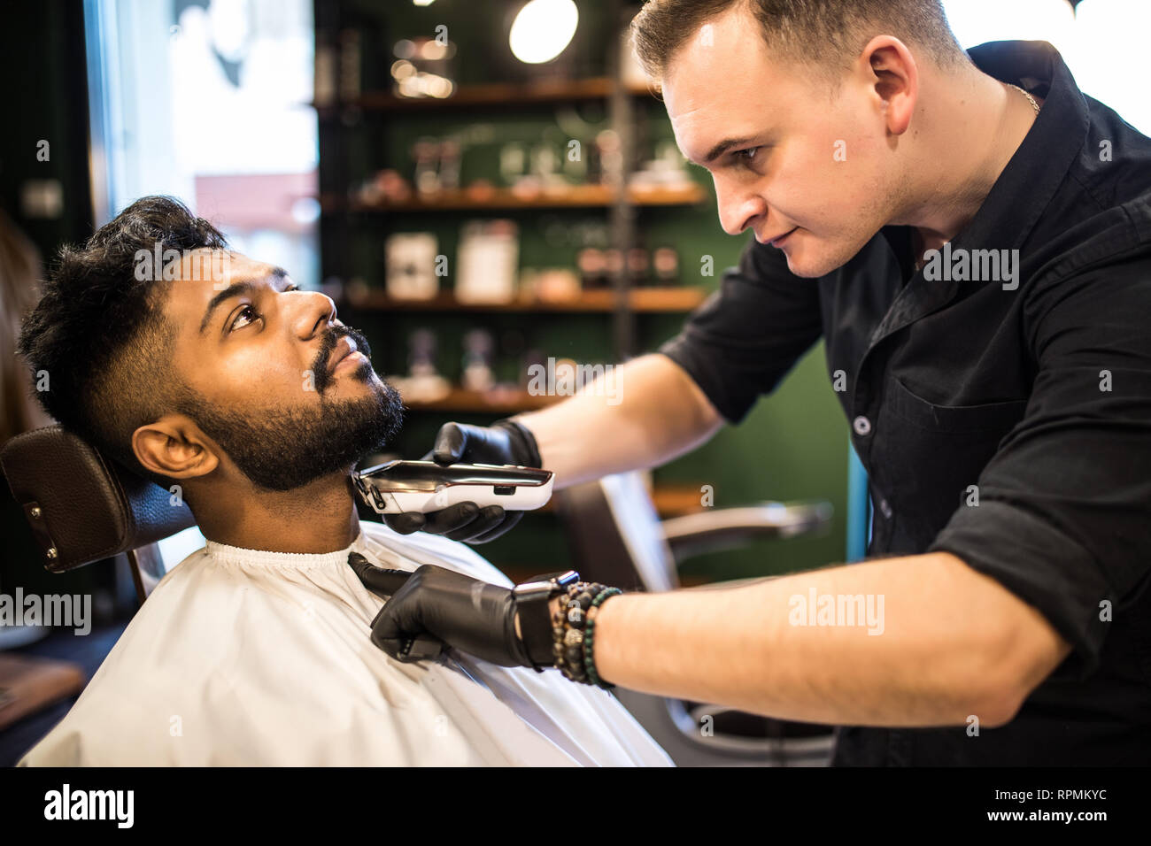 Client during beard and moustache grooming in barber shop Stock Photo