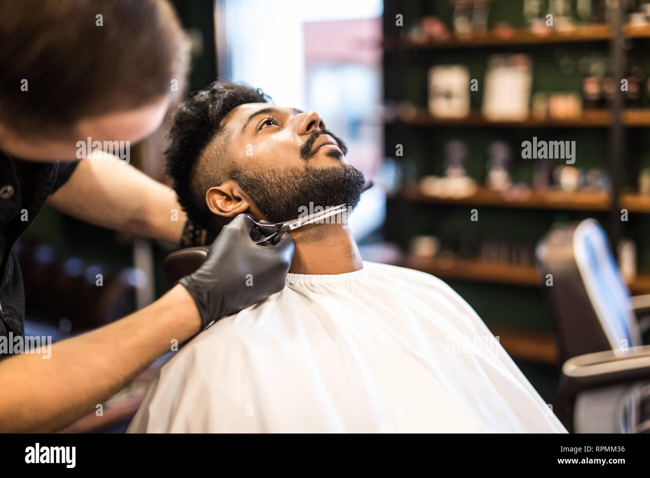 Close Up Side View Of Young Bearded Man Getting Beard Haircut By