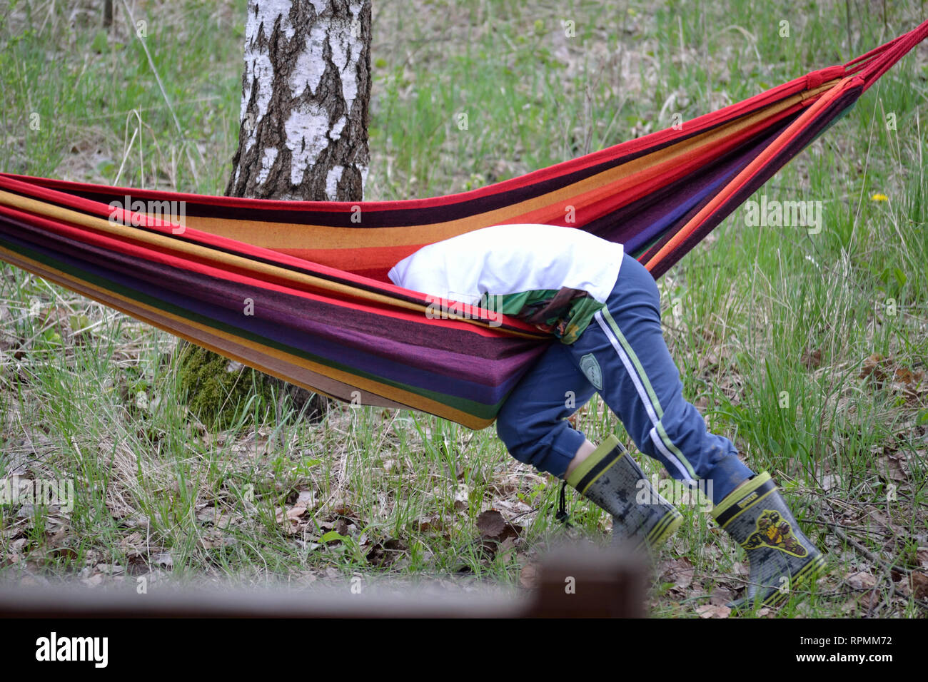 Child playing with hammock and falling down Stock Photo