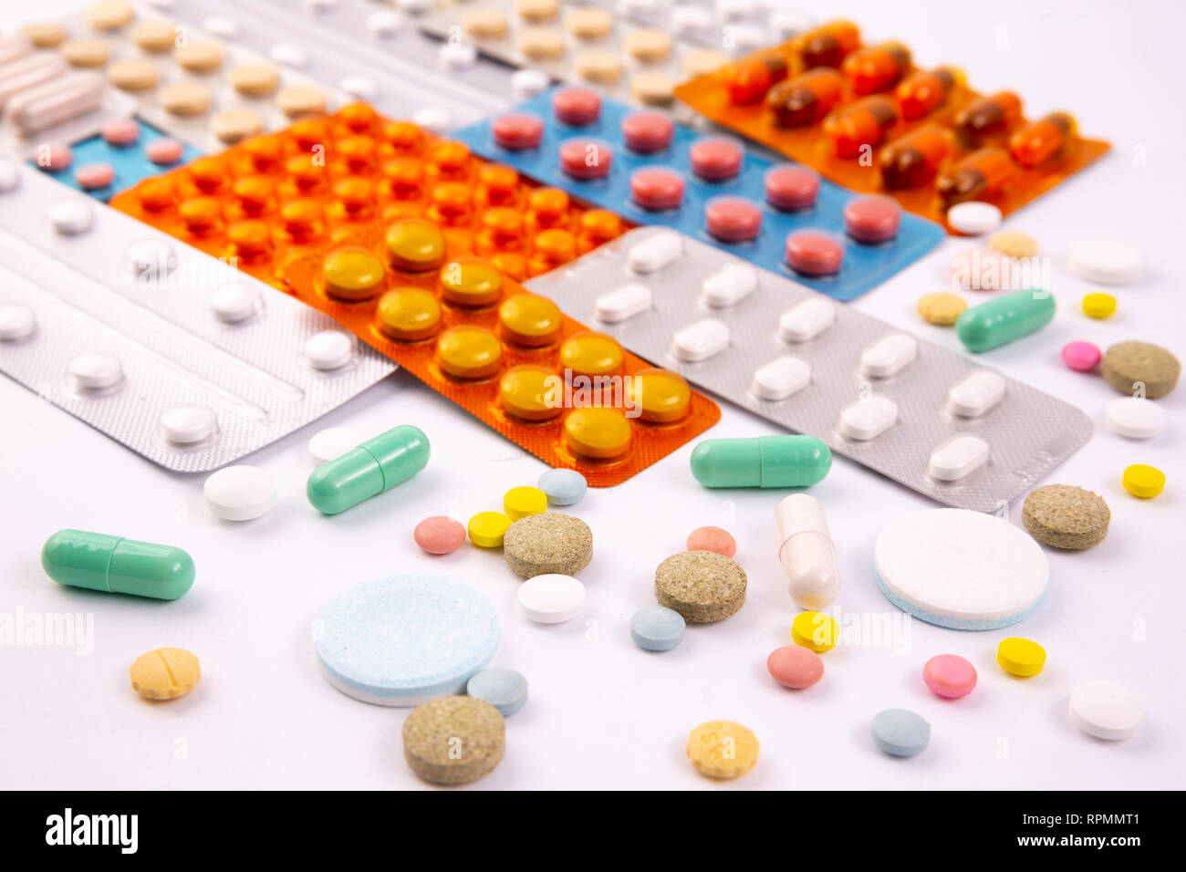 Different colorful pills and capsules in plastic packs - blisters stacked. Global pharmaceutical industry for billions dollars per year. Pharmaceutica Stock Photo