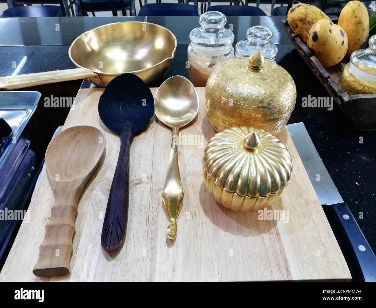 Cookware brass, luxury cooking utensils on wood chopping board Stock Photo