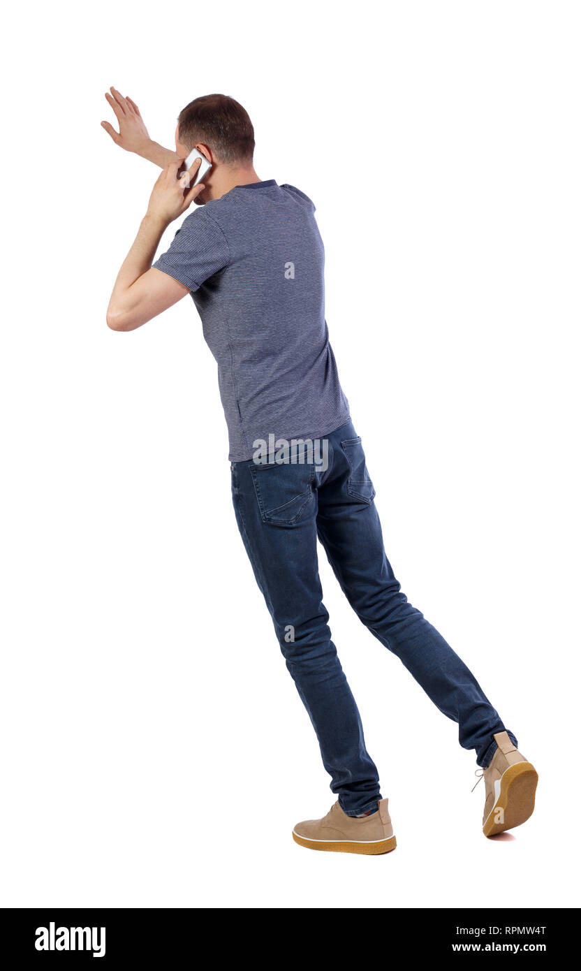 back view of walking man. guy going, pointing and talking on smartphone ...