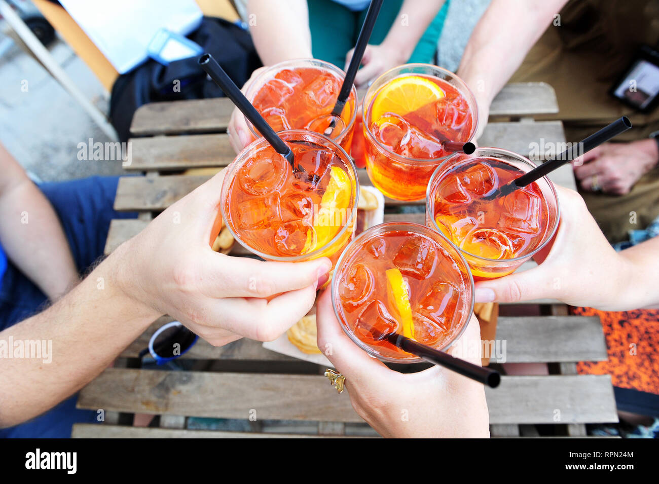 A close-up of hands of several people making a toast with Spritz Stock Photo
