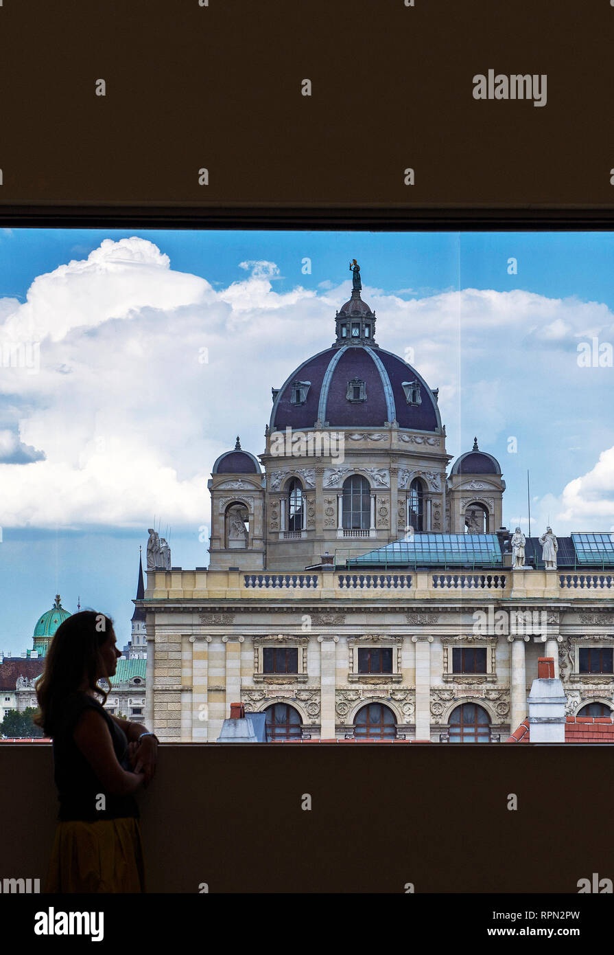 Young woman admiring the view of the Kunsthistorisches museum from a window inside Leopold Museum, Vienna, Austria Stock Photo