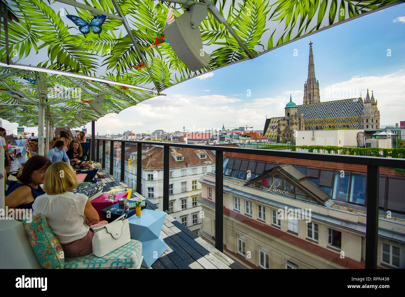 People having a drink and enjoying the view over Stephansdom from the rooftop bar of Lamée hotel in Vienna, Austria Stock Photo