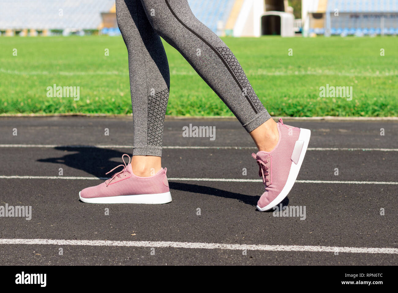 Girl legs in pink sport shoes standing on a running track with stadium  stands. Sports and healthy concept Stock Photo - Alamy