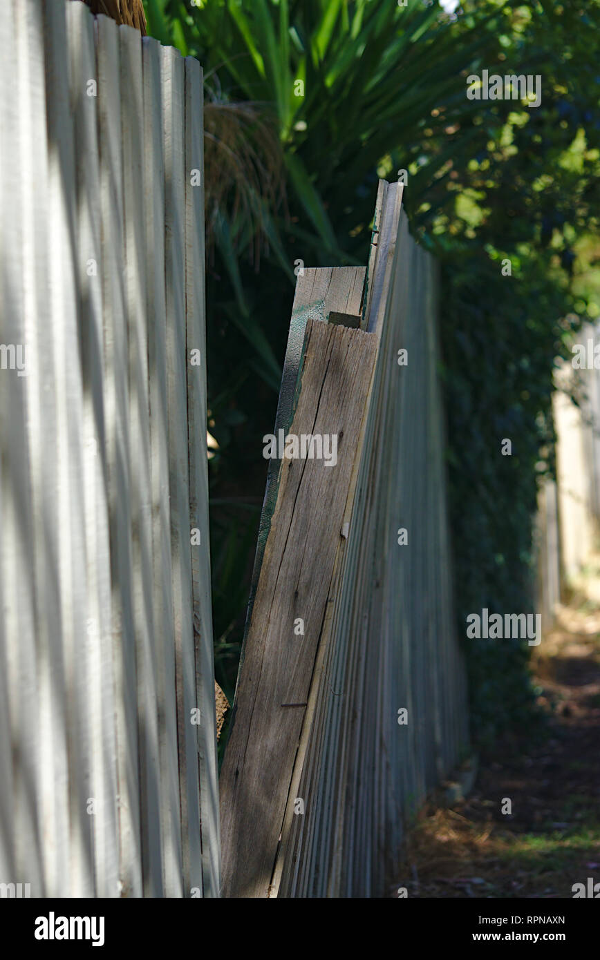 Broken tilted almost fallen wooden fence Stock Photo