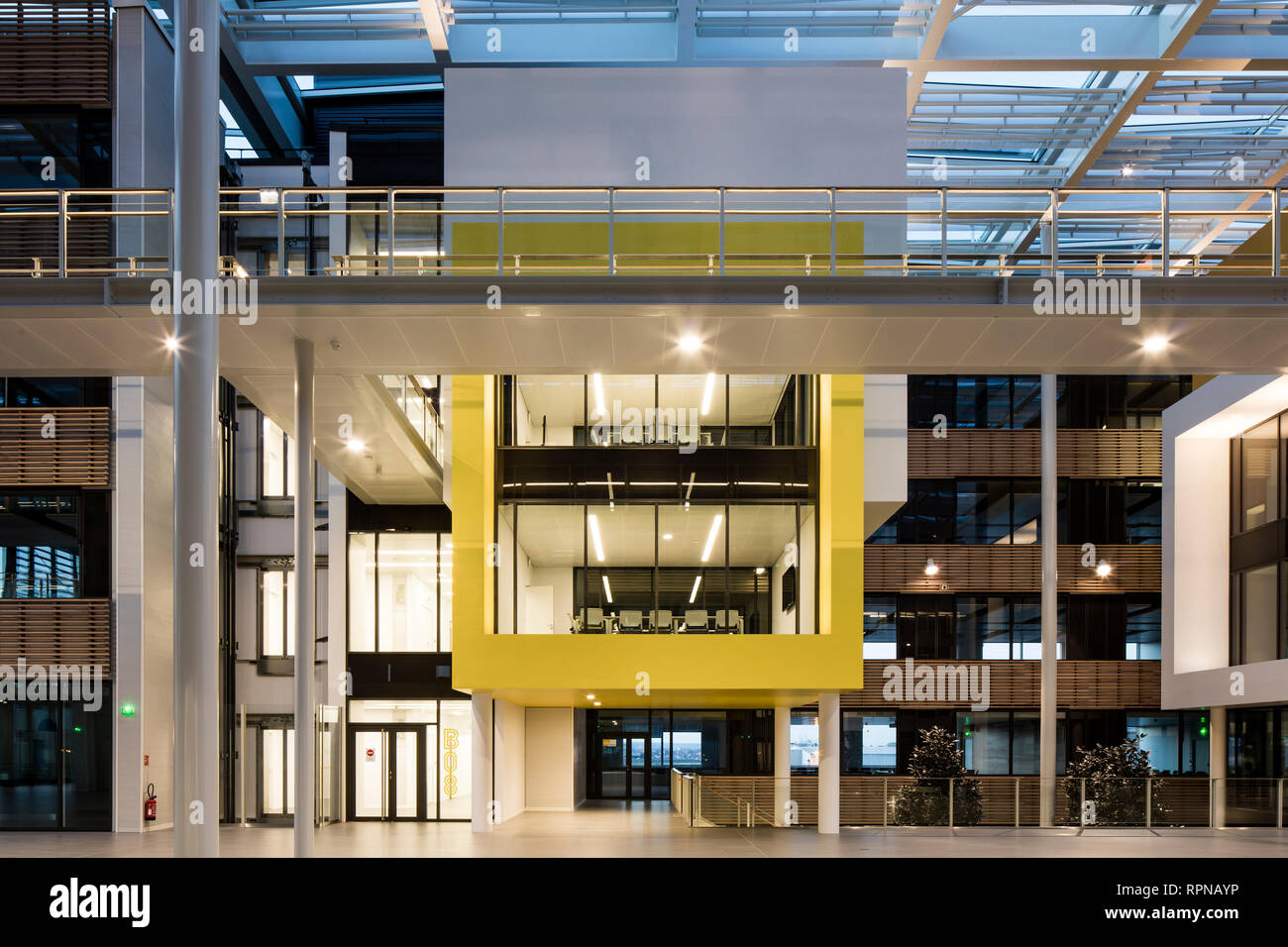 Dusk elevation of rectangular volumes and glass roof. Research Centre