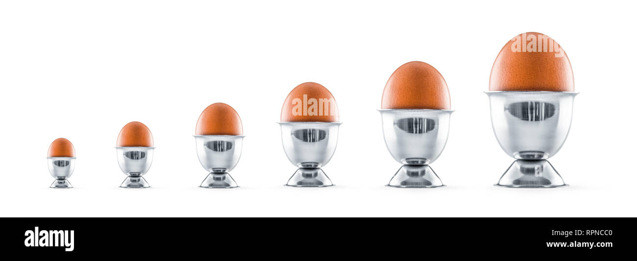 Six eggs in egg cups isolated on white background. Stock Photo